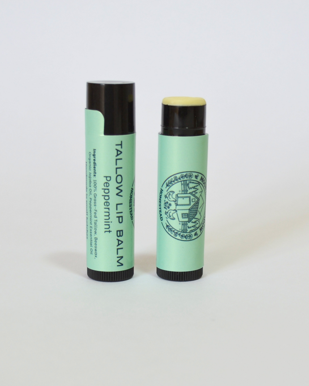 Two green lip balms with black caps on a white background, Peppermint tallow lip balm