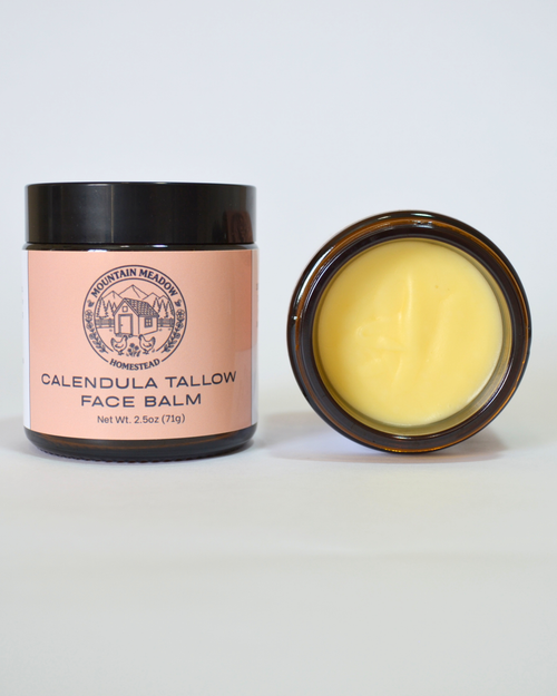 Calendula tallow face balm with a pink container and black lid on a white background